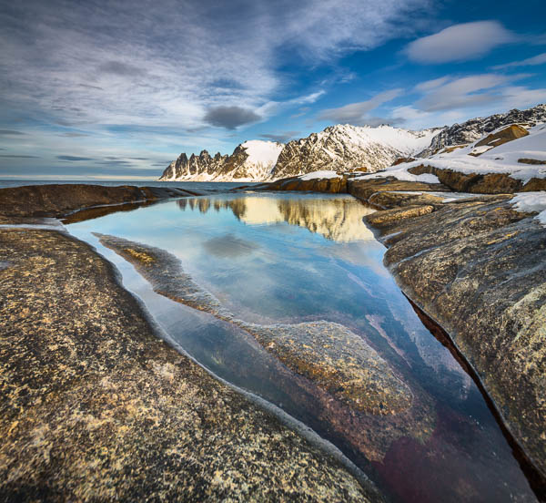 De bergketen Okshornan weerspiegelt in een getijdenpoel bij de Ersfjord op het eiland Senja in Noord Noorwegen; The mountain range Okshornan reflects in a tidal pool of the Ersfjord op Senja in het noorden van Noorwegen