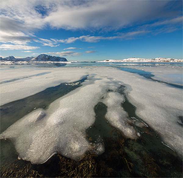 Winters landschap met grillige vormen van ijs voor de kust bij het plaatsje Sandøya in het noorden van Vestvågøya, één van de eilanden van de Lofoten