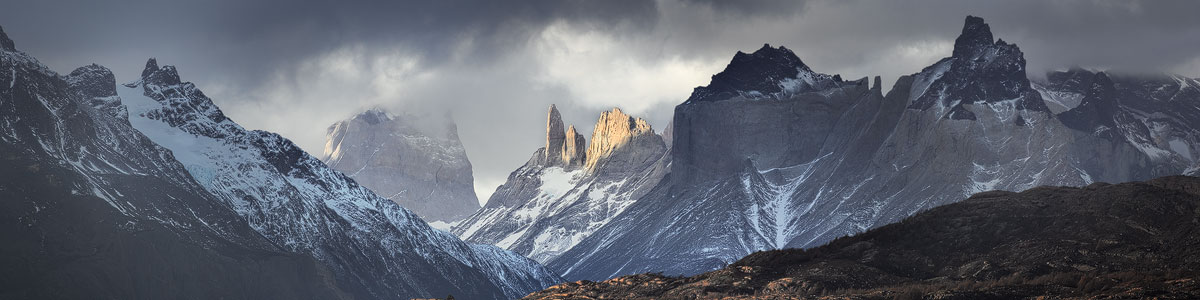 Patagonië fotopagina, Chris Stenger Natuurfotografie, Landschapsfotografie en Reisfotografie. De foto toont Het Paine massief in het Torres del Paine Nationaal Park in Chileens Patagonië gehuld in wolken